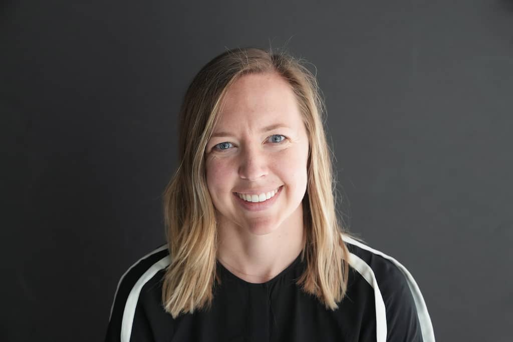 A headshot of Veronica, smiling on a dark background.